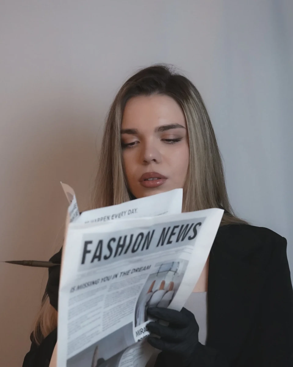 Žena u crnom sakou čita modne novine