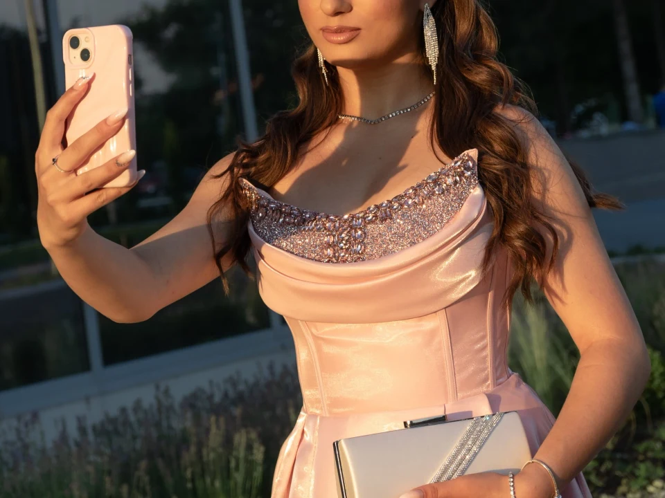 Žena u svečanoj haljini pravi selfi telefonom